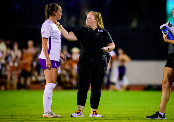 LSU soccer player and LSU athletic trainer on soccer field