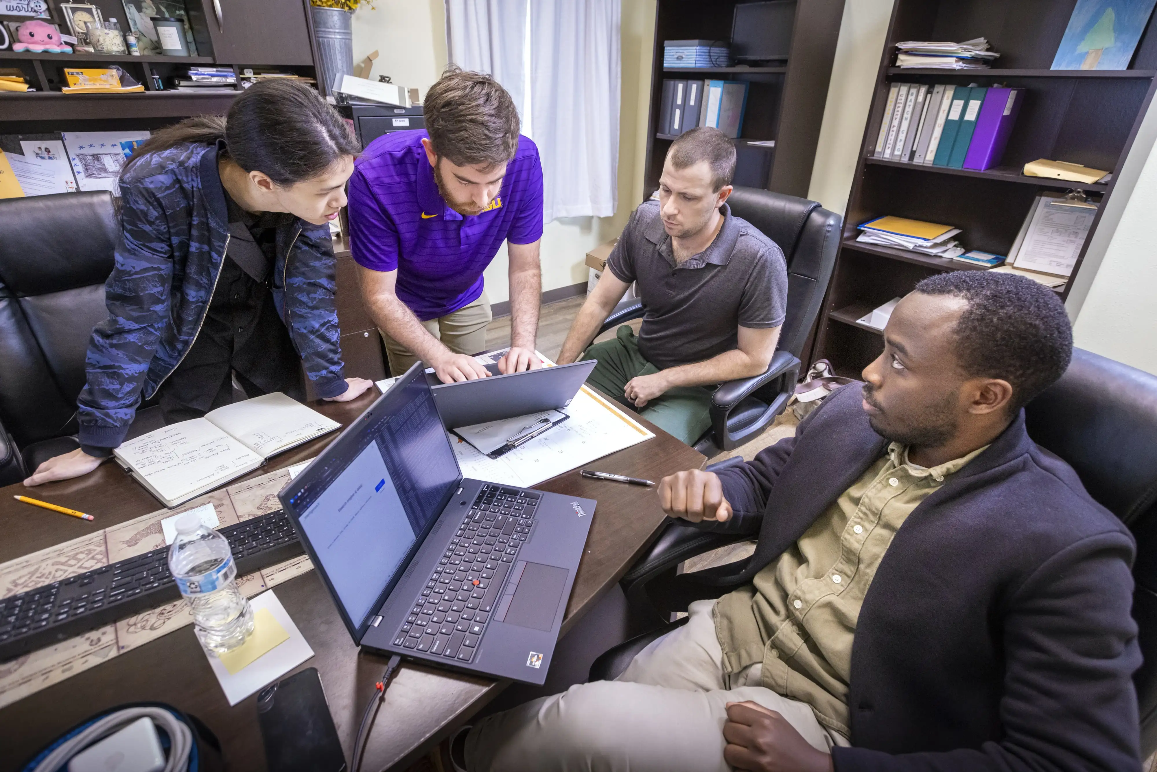 Three students actively helping a real client